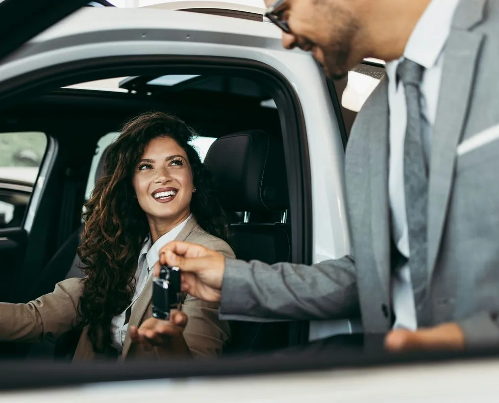 Lady getting car keys from dealership